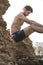 Young sexy man outdoor portrait sitting on a rock, topless