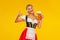 Young sexy Oktoberfest girl waitress, wearing a traditional Bavarian or german dirndl, serving big beer mug with drink