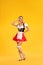 Young sexy Oktoberfest girl waitress, wearing a traditional Bavarian or german dirndl  on yellow background