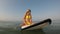 Young sexy woman sits on a surfboard in the sea. Surfer girl in the sea