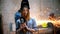 Young sexy woman standing in the industrial grinding workshop holding an angle grinder