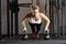 Young sexy woman with strong hands exercising at professional crossfit center