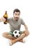 Young shocked emotional supporter sitting on the floor and watching soccer with beer