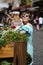 Young shorthair caucsian woman in blue dress and suglasses smiling while walking in sunny street