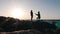 Young shy man making an offer to his beloved girl on the seashore at sunset. Attractive man standing on his knee and making an off