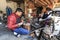 Young silversmith working on his workshop along with another woman dressed with the traditional Bai attire.