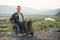 Young sirious man in wheelchair enjoying nature beauty on the mountains. People with disabilities travelling.