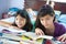 Young sisters enjoying their reading in home envir