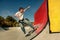 Young skateboarder flies with his board on the ramp of a skate park