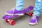 Young skateboarder in gumshoes and jeans stands