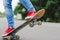 Young skateboarder legs riding on skateboard on city