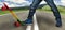 A young skateboarder in sneakers and jeans, standing on his skate. Closeup fragment of the skateboard and feet.