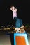 Young skater doing trick slide on railing in skatepark at night