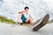 Young skater resting sitting on his skateboard in a skatepark