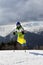 Young skier jump with ski poles in sun winter mountains and cloudy gray sky