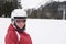 Young skiing woman wearing black goggles, white helmet and red j