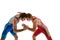 Young skilled wrestlers in blue and red uniform hand wrestling in neutral position on their feet against white studio