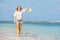 Young skinny caucasian girl at the beach waving