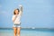 Young skinny caucasian girl at the beach waving