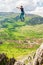 Young slackliner man balancing on a slackline betweend two rocks. Highline with a beautiful natural landscape behind