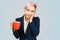 Young sleep girl office worker holds cup of coffee on a blue background