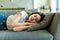 Young sleeping woman is lying on a pillow on a couch