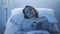 Young sleepless patient lying in the hospital bed and reading a book