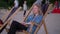 Young sleeply woman sits on the beach chair and watches environment. Beautiful female holds her drink and waits for