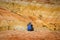 Young slender girl traveler on the background of fantastic Martian landscape in  Altai mountains. Woman in cap with backpack