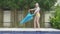 Young slender woman dances an oriental dance near pool in tropical resort