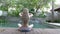 The young slender woman with long hair meditates on the edge of the pool in the tropical resort