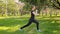 A young, slender woman in a sports uniform does a lunge exercise to train the muscles of the legs. Fitness classes in nature
