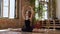 A young slim ballerina in black tutu making twine in the dancing hall. Beautiful ballet dancer practicing splits pose