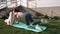 Young slim beautiful healthy hipster female outdoors doing sport activity exercise with resistence band on the yoga mat