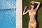 Young slim beautiful woman in yellow bikini sunbathing