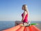 Young slim blonde girl in pink tank top at sea