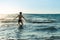 Young, slim, Caucasian woman black bikinis walking in the sea with splashes