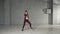 Young slim girl performing contemporary dance in studio.