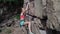 Young slim muscular woman rockclimber climbing on tough sport route, climber makes a hard move.