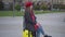 Young slim stylish Caucasian woman in red beret and eyeglasses sitting on yellow travel bag waiting. Portrait of