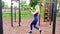 Young slim woman with blonde hair doing workout outdoor in the park, slow motion