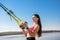 Young slim  woman doing suspension training with fitness straps outdoors near the lake at daytime. Healthy lifestyle