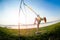 Young slim  woman doing suspension training with fitness straps outdoors near the lake at daytime. Healthy lifestyle