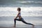 Young slim woman training on the beach.