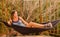 Young slim woman in tropical exotic hammock sunset lights