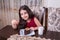 Young small beautiful middle eastern child girl with chocolate cake with pineapple, strawberry, and milk with red dress and dark