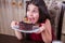 Young small beautiful middle eastern child girl with chocolate cake with pineapple, strawberry, and milk with red dress and dark