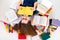 Young and smart girl lying with book surrounded by colorful book