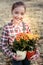 Young smart schooler taking plants in colorful plant