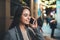 Young smile woman calling mobile phone on background bokeh light in night europe city. Girl  using smartphone technology